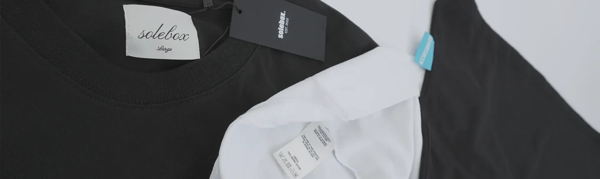 Verschiedene Optionen für Textil Finishing: Ein Weblabel im Nackenbereich Innen, ein individueller und hochwertiger Hangtag, ein Flaglabel außen am Shirt und ein individuell gebranntes Carelabel.
