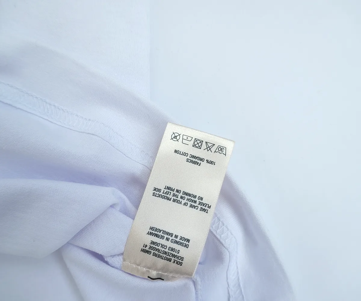 Ein Carelabel an einem weißen T-Shirt, das Pflegehinweise zum Waschen, Trocknen und Bügeln des T-Shirts