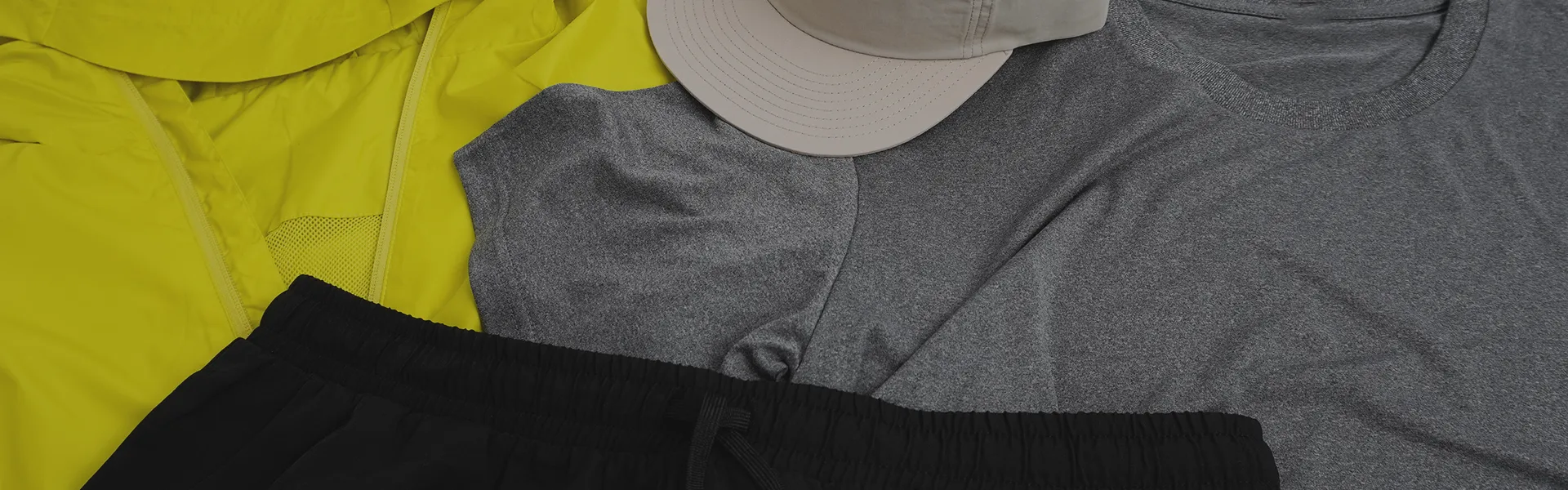 Eine wasserabweisende Funktionsjacke, ein graues Funktionsshirt, eine Running Shorts und eine Sport Cap - Alles ideal zum Laufen